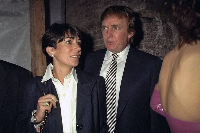 Two people at an event in formal attire, one wearing a dark suit with a striped tie, and the other in a blazer with a white shirt