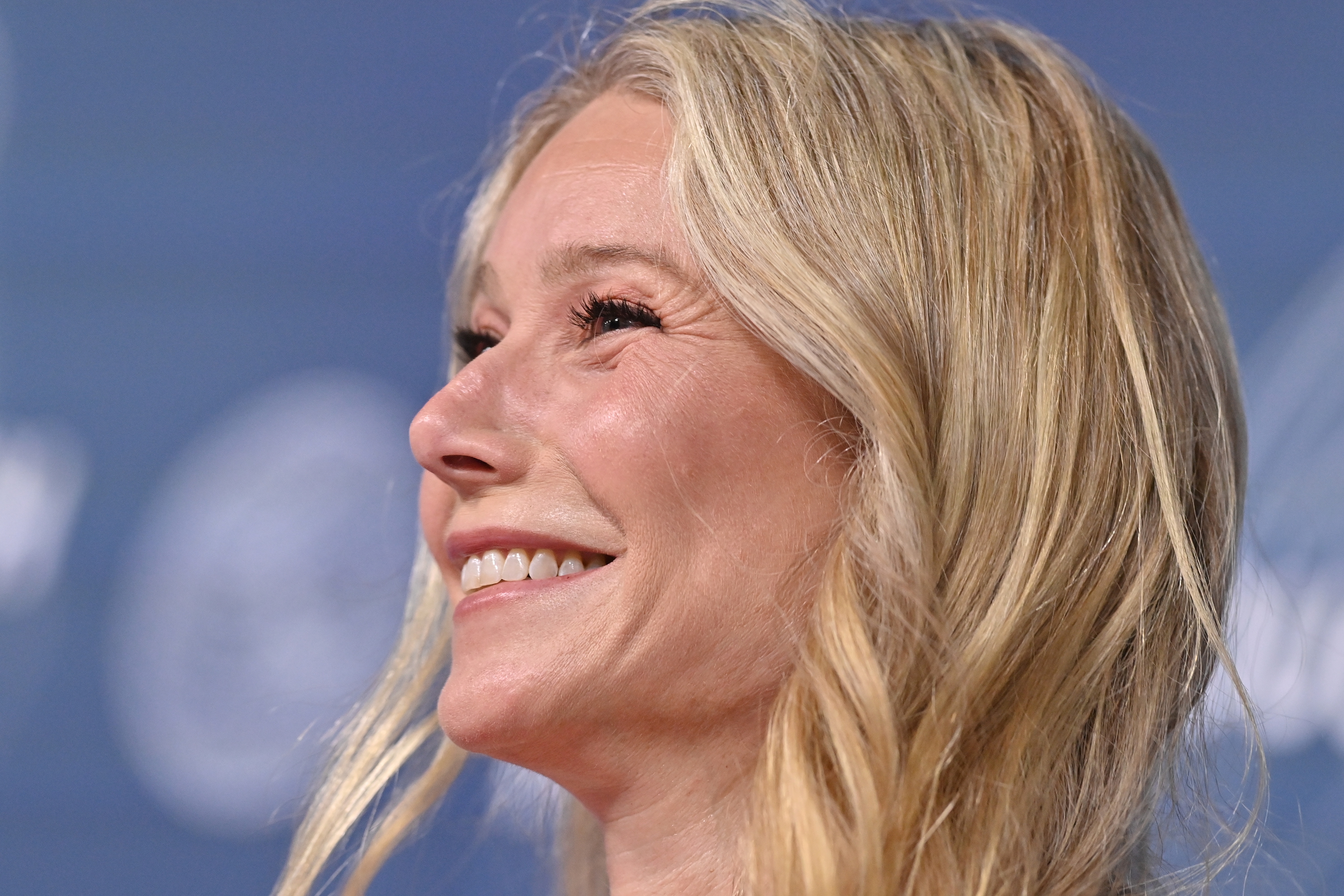 Gwyneth Paltrow smiling warmly at an event, with long, wavy hair