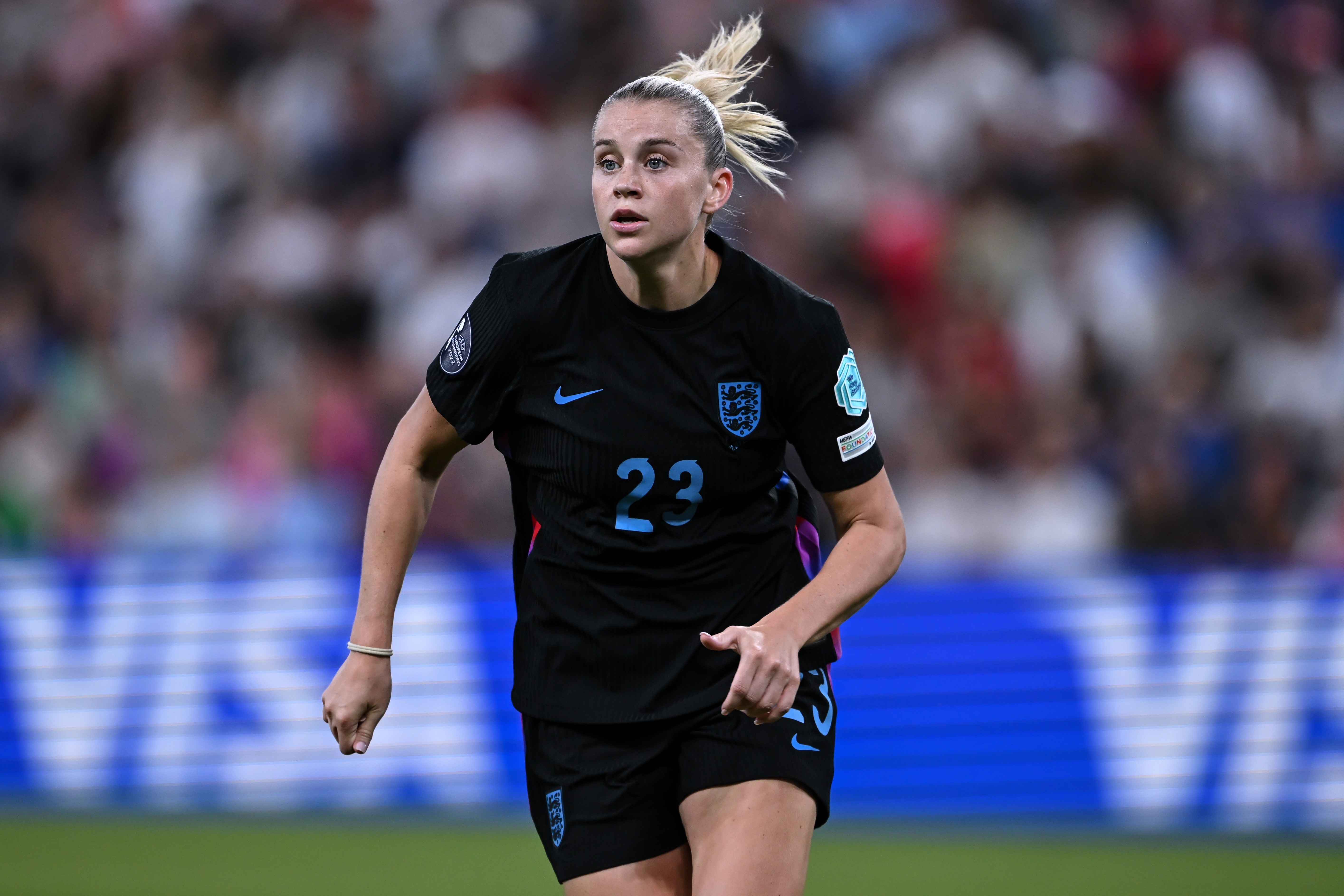 Soccer player in action, wearing a black jersey with the number 23, looking focused during a match