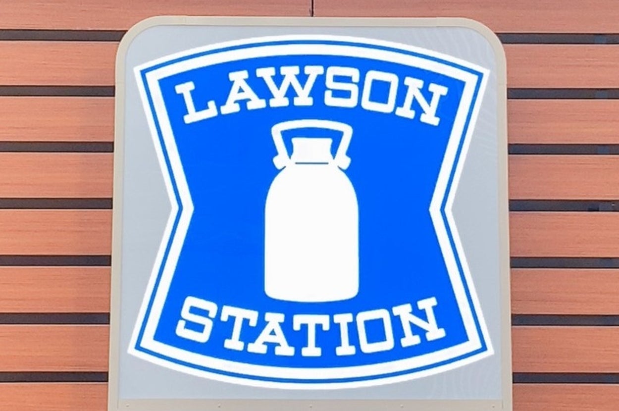 ローソンのロゴ看板。青い背景に白いミルク缶のイラストが描かれ、上下に「LAWSON STATION」と記載されています。