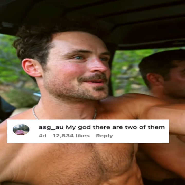 Two shirtless people sitting in a vehicle outdoors, smiling and looking to the side. One person wears a necklace