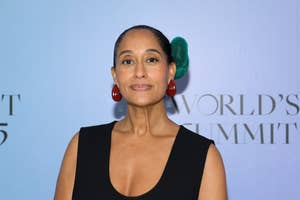 Tracee Ellis Ross at a summit event wearing a sleeveless dress and bold accessories