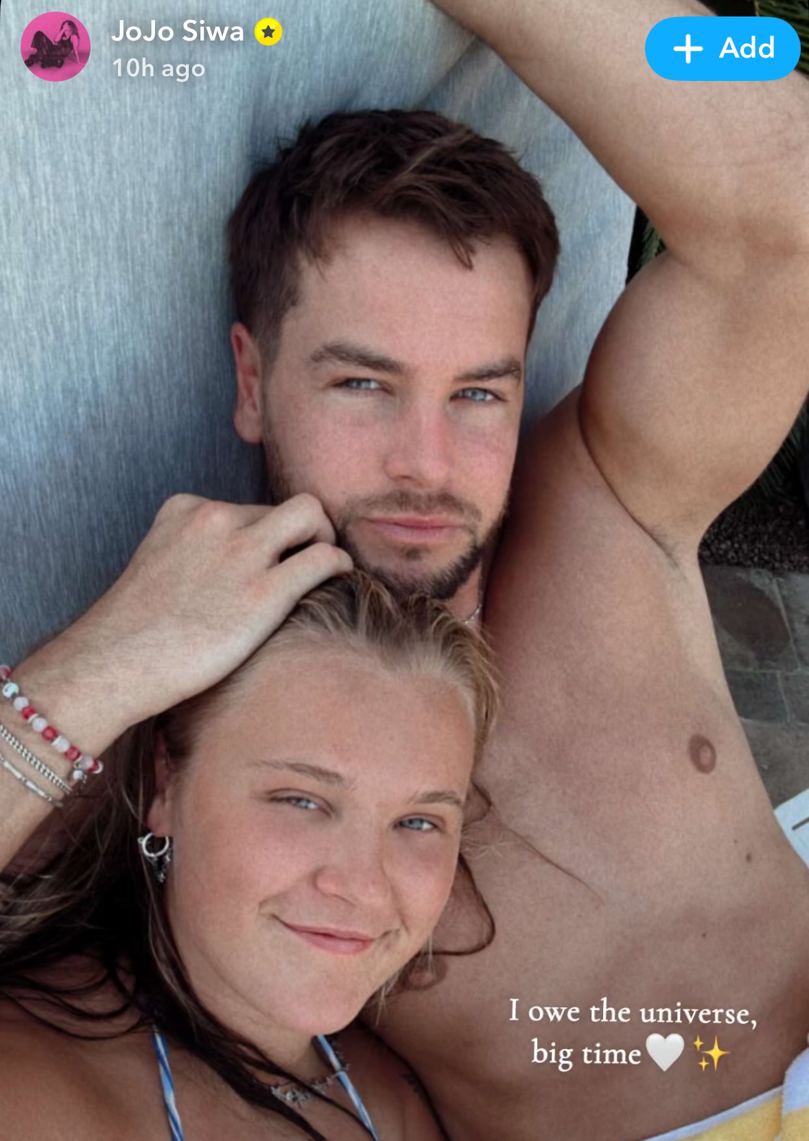 Two people relaxed on a sunbed, with the text "I owe the universe, big time" in the image