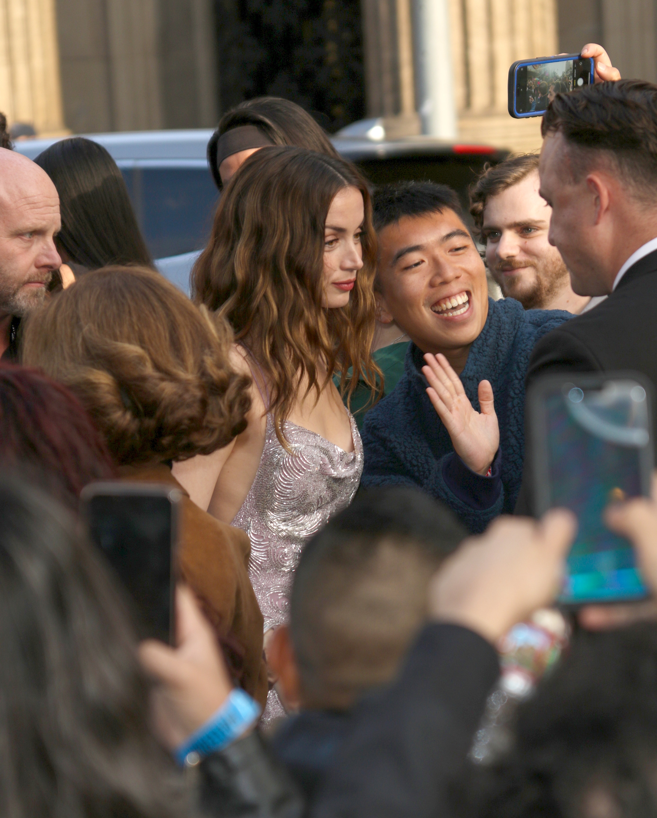 Ana De Armas in a shimmering gown greets fans and poses for photos at an event