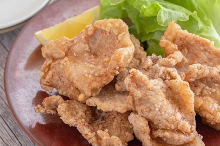 一皿の唐揚げとレタス、レモンが盛り付けられた食事。