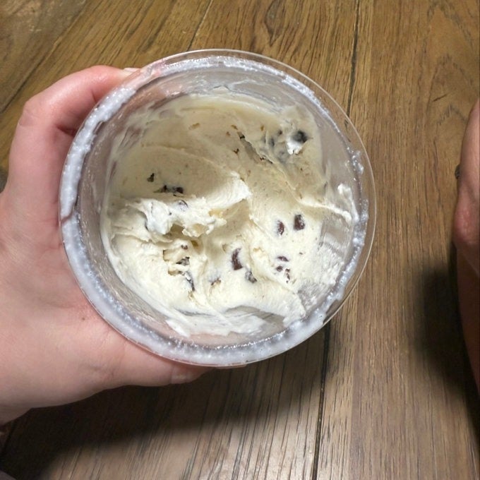 Person holding a tub of cocoa  spot   crystal  pick  connected  a woody  table