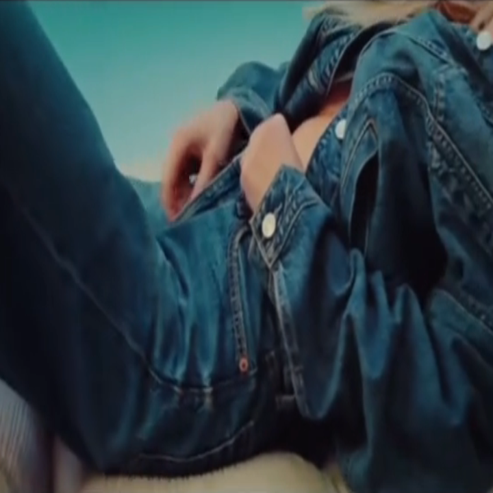 Person lounging in denim outfit, reclining comfortably outdoors