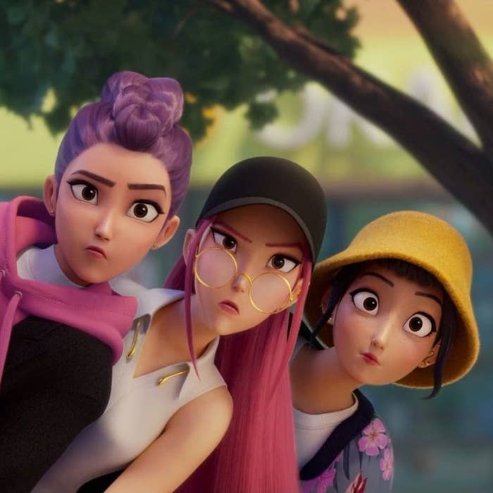 Tres personajes animados con expresiones de sorpresa. Uno lleva gafas redondas, otro sombrero amarillo, y otra tiene un moño alto