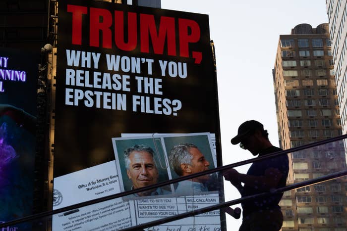 Billboard asks Trump to release Epstein files, with photos of Epstein, seen in silhouette on urban stairs