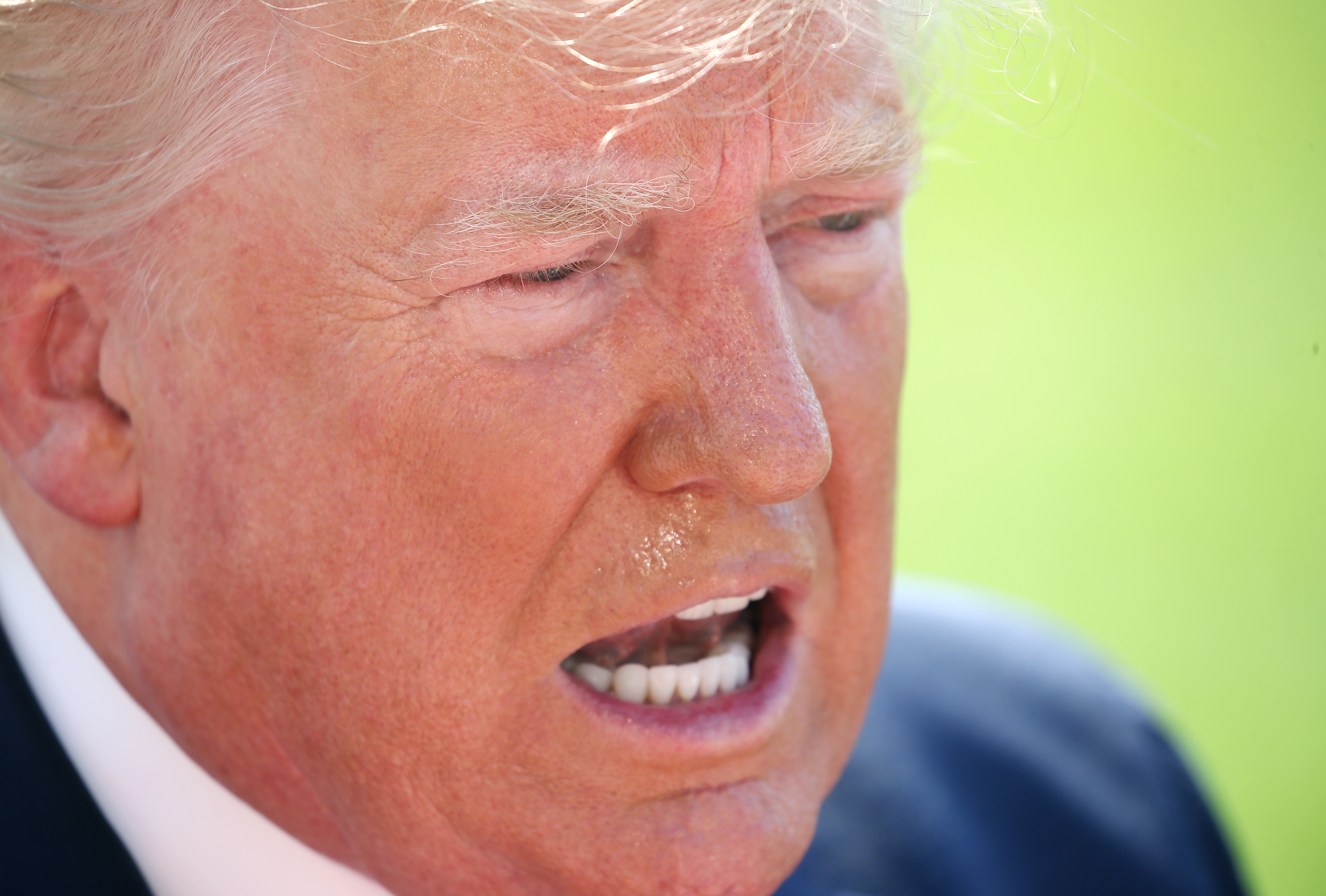 A person speaking with an open mouth, captured in a close-up image