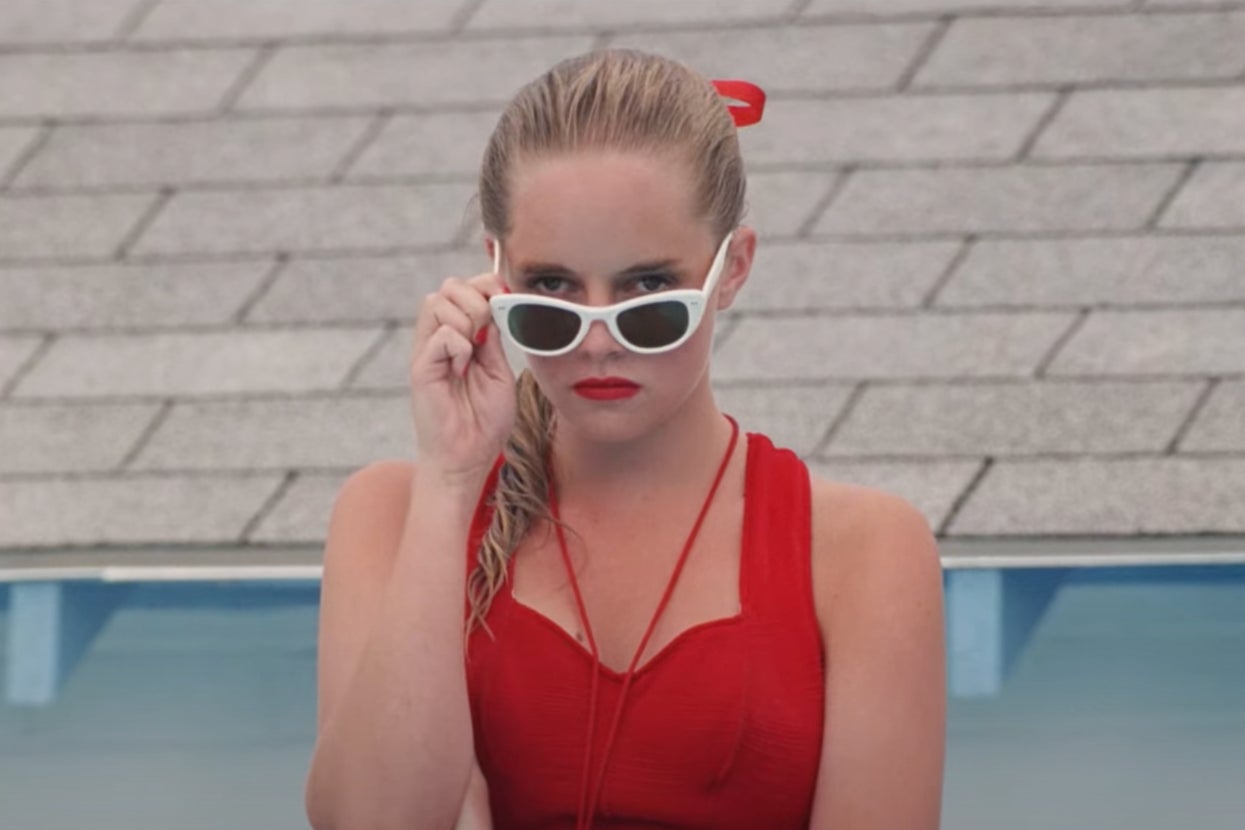 Wendy Peffercorn, played by actress Marley Shelton in "The Sandlot" in a retro-style red swimsuit and white sunglasses, tilting them down to look directly at the viewer