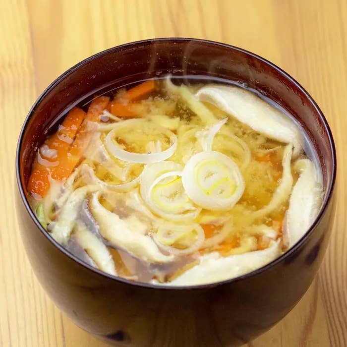 湯気の立つ味噌汁には、ネギ、にんじん、きのこが具として入っている。