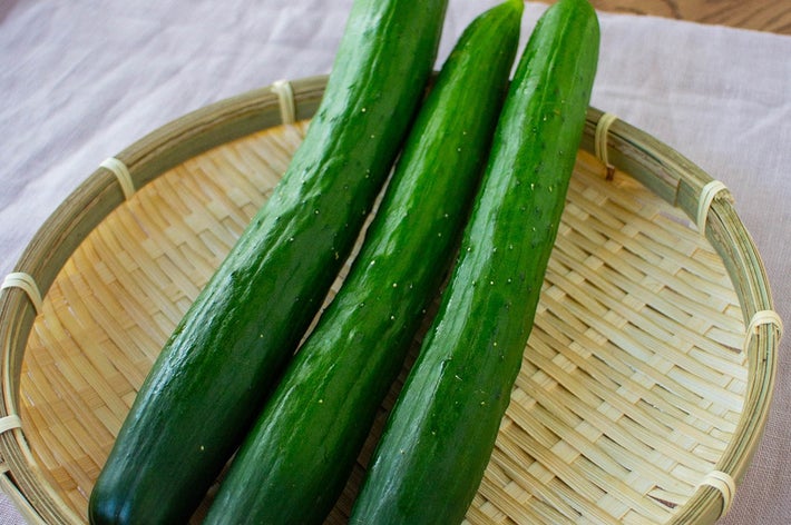 ざるの上に3本のきゅうりが載っています。