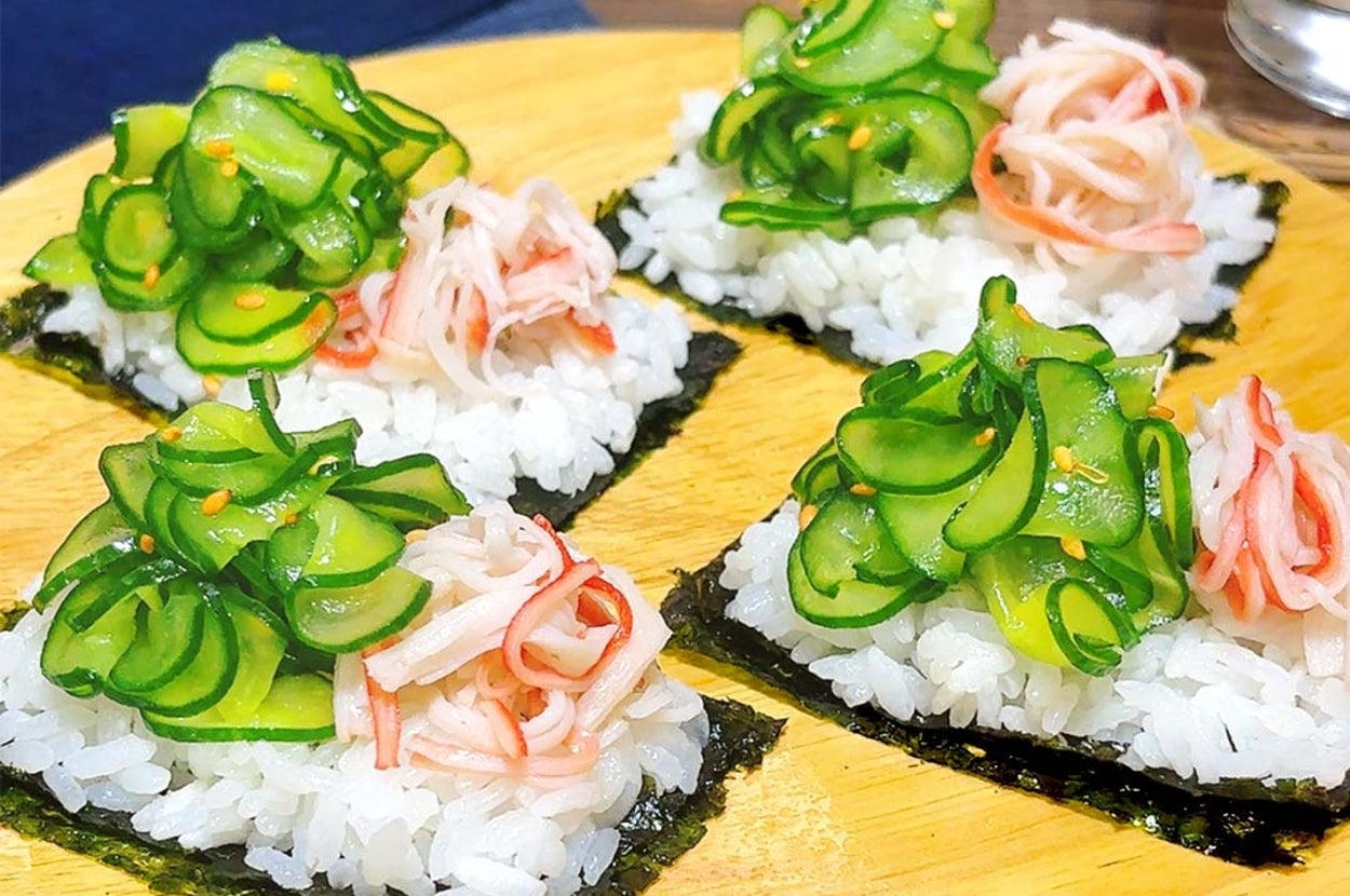木の皿に盛られた海苔付きのお寿司。シャリの上に薄く切ったきゅうりとカニ風の具材がのっています。