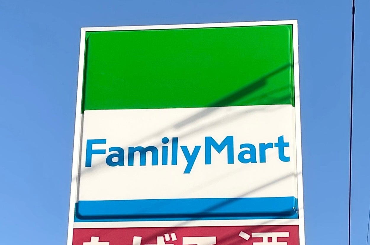 ファミリーマートの店舗看板。青空の背景に緑と白のデザインが特徴的。