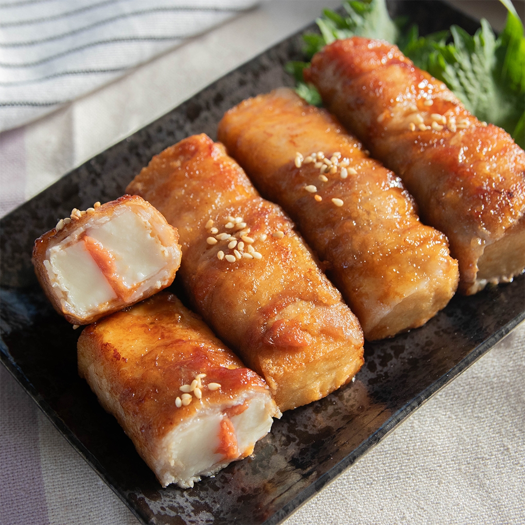 お皿に盛られた梅入り厚揚げの肉巻き。白いりごまがトッピングされている。