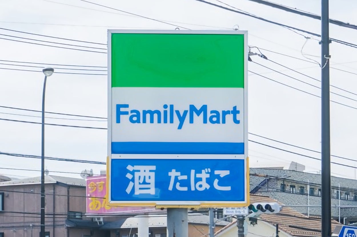 ファミリーマートの看板があり、下に「酒 たばこ」と書かれています。建物や電線が背景に見えます。