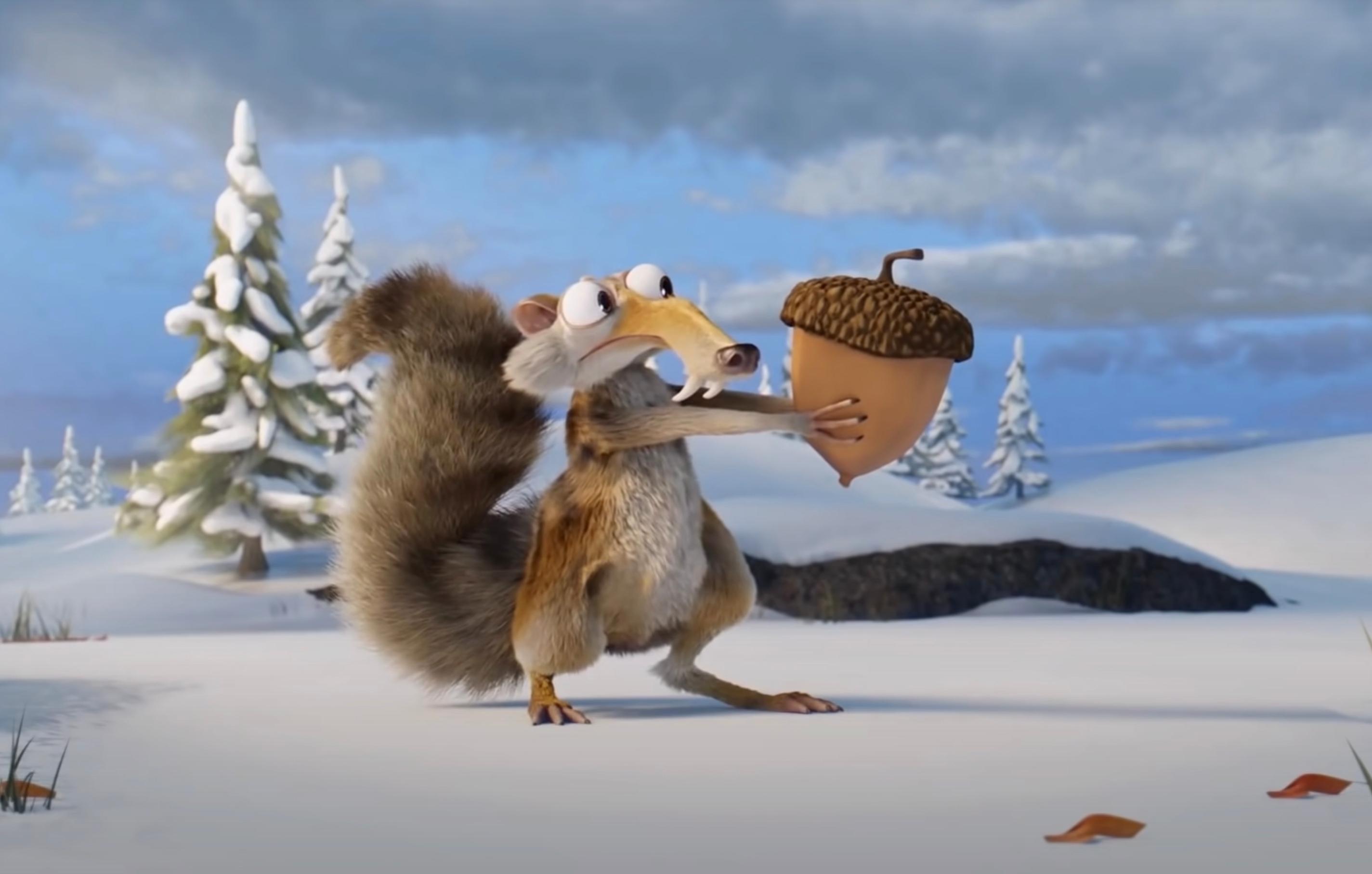 Scrat from Ice Age excitedly holds an acorn in a snowy landscape with trees