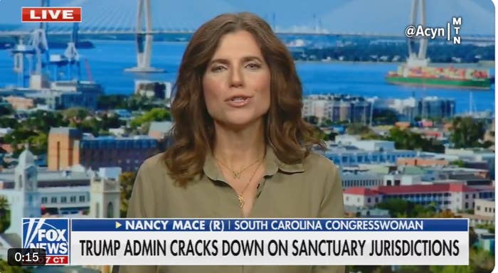 A woman in a studio discusses the Trump administration's actions on sanctuary jurisdictions. Background view of a cityscape and a bridge