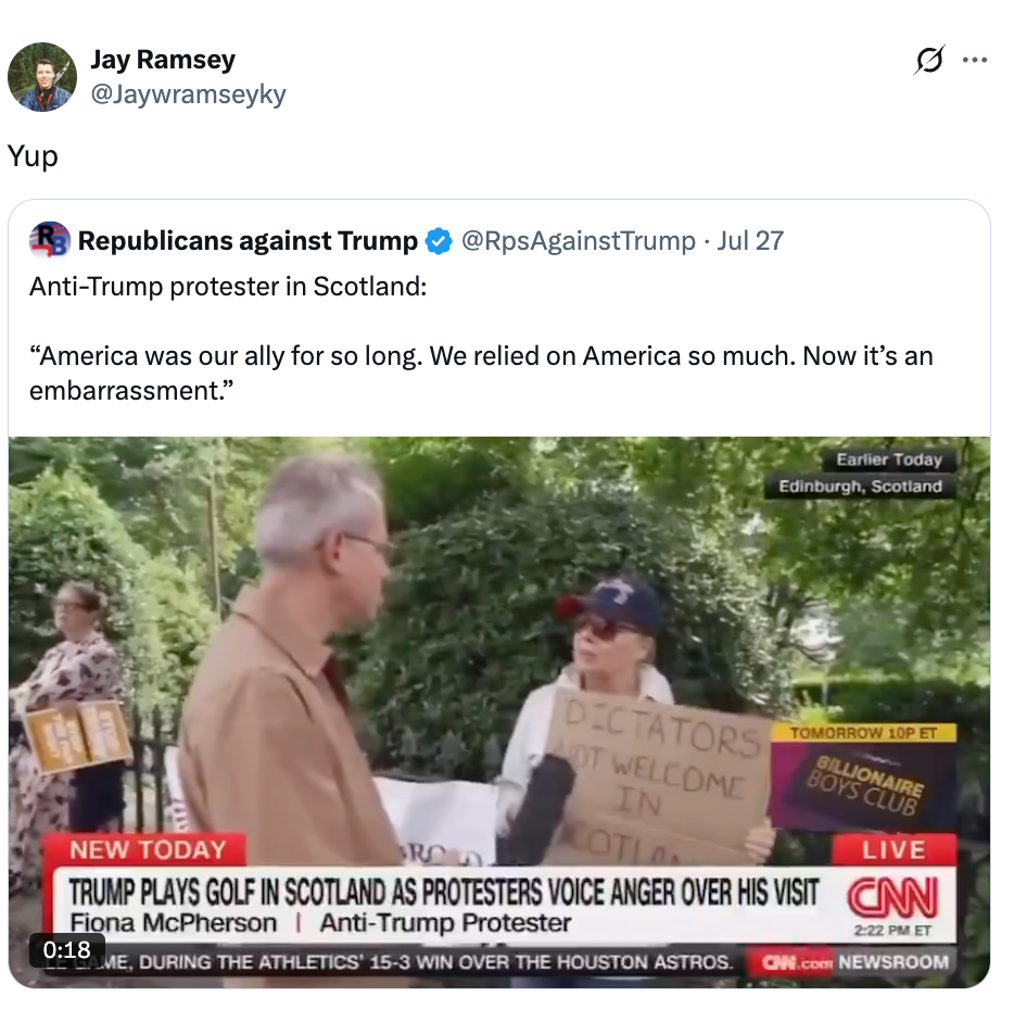 A protester in Scotland holds a sign reading &quot;Dictators not welcome in Scotland&quot; during an anti-Trump demonstration as a reporter interviews them