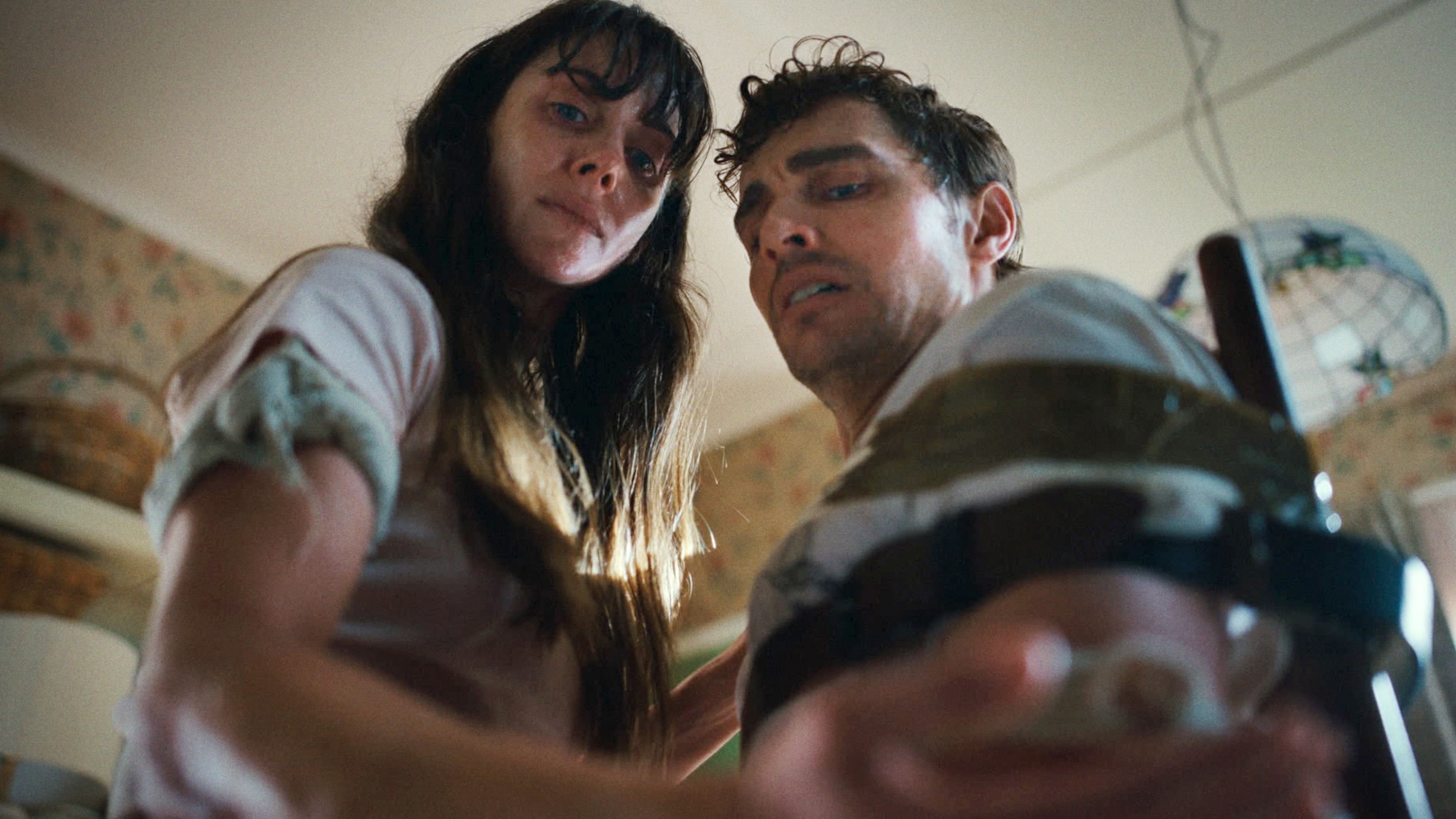 A tense scene with a woman looking distressed and a man tied to a chair, appearing alarmed