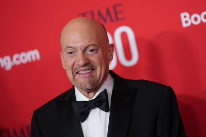 Person in a tuxedo at a formal event with a red backdrop featuring &quot;TIME 100&quot; text