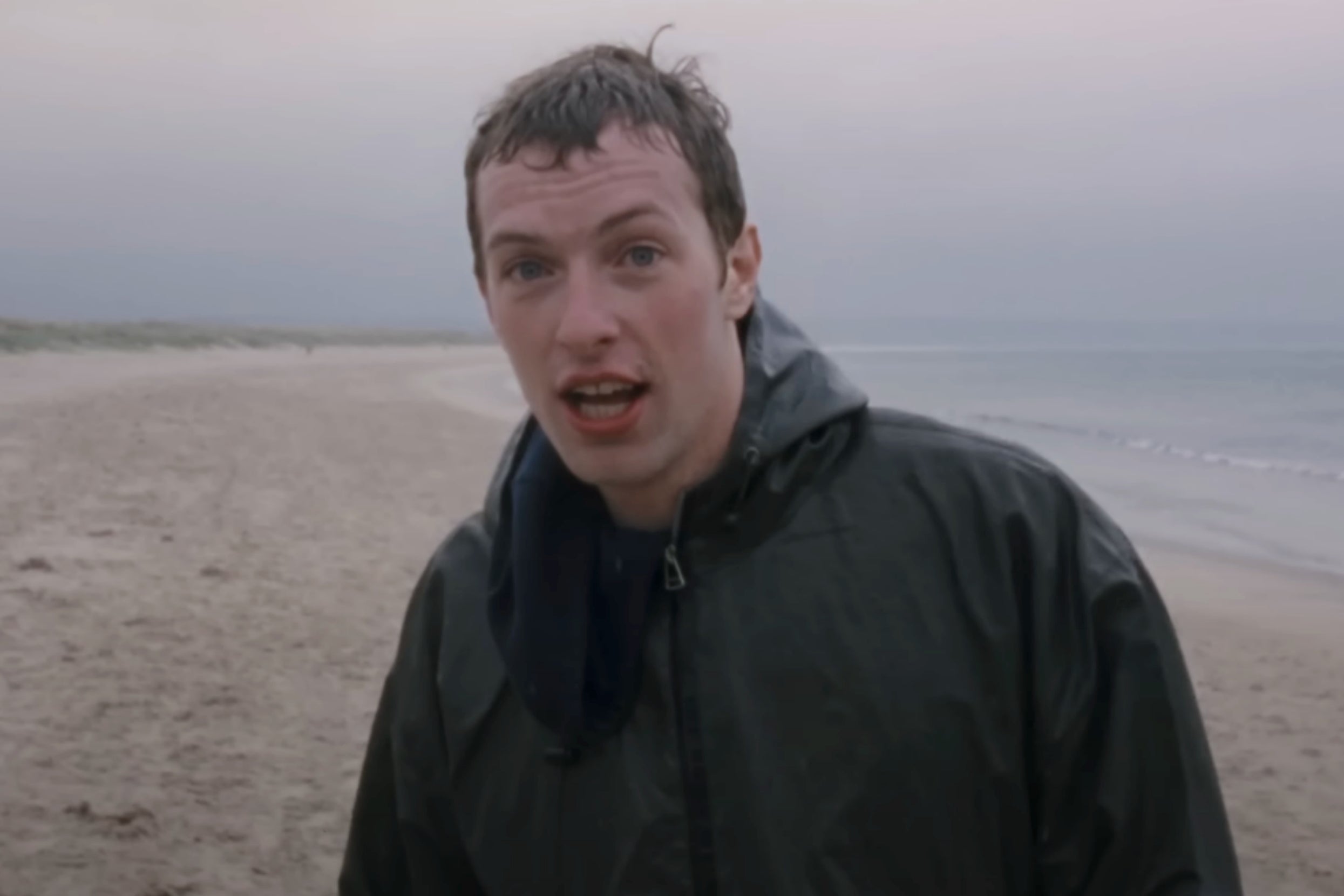 Chris Martin on the beach in Coldplay's Yellow music video
