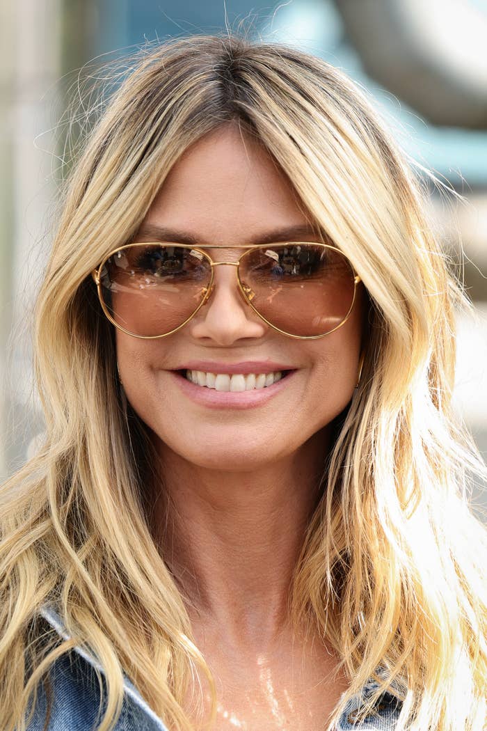 Heidi Klum with long hair and sunglasses smiling at the camera
