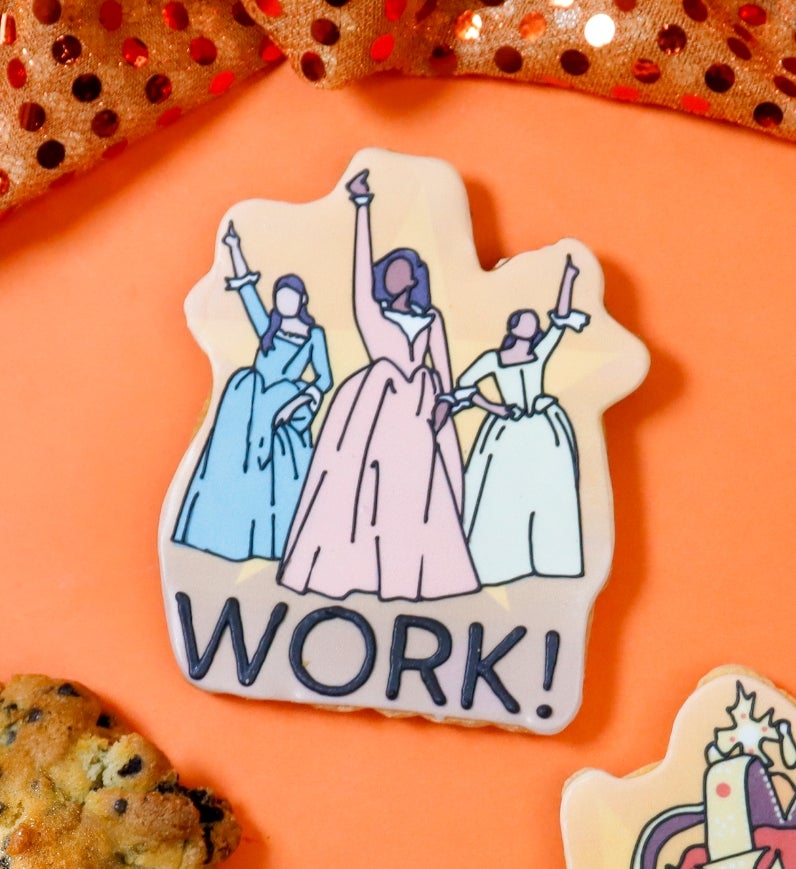 Cookies next to iced biscuits with cartoon designs and text: "WORK!" and "Awesome. Wow." Set against a sequin fabric backdrop