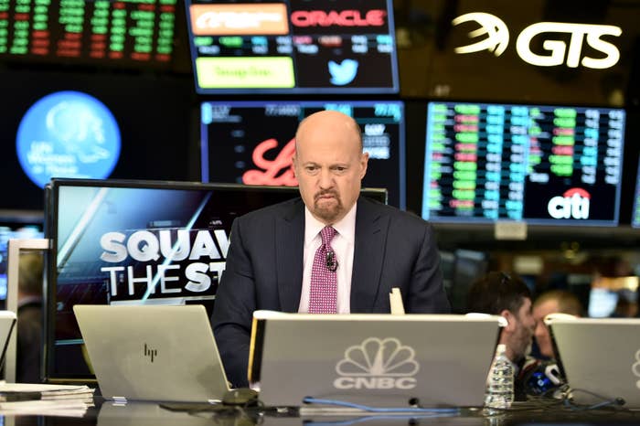 Man in suit on CNBC set with stock monitors in background, appearing focused and engaged in financial analysis