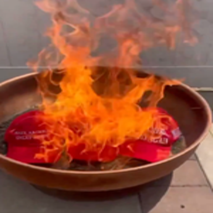 Hats burning in a fire pit, engulfed in flames, representing a strong statement or protest