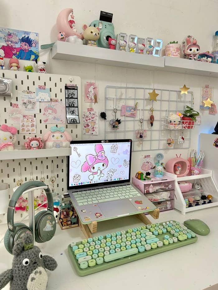 Estación de trabajo decorada con temática de Sanrio y personajes adorables, con teclado pastel, auriculares y accesorios de escritorio detallados