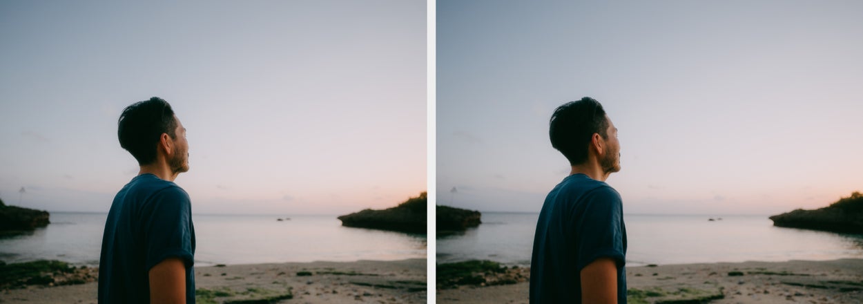 Person stands on a beach, gazing at the horizon with calm water and a clear sky