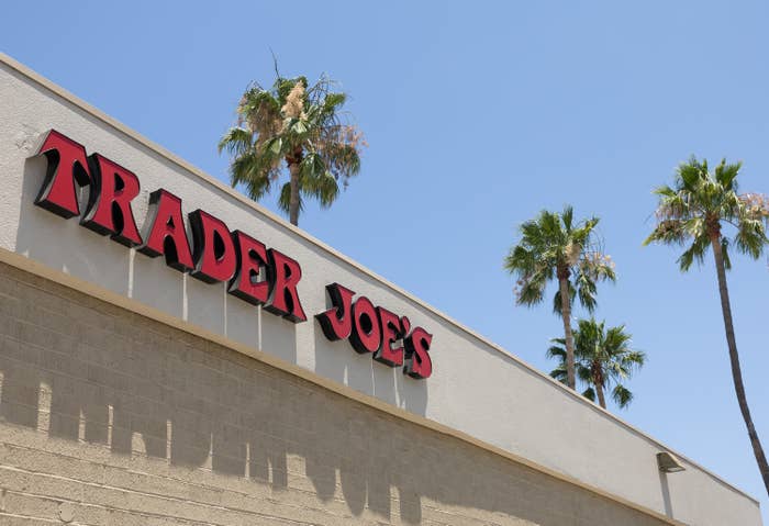 Trader Joe's storefront with palm trees in the background against a clear sky