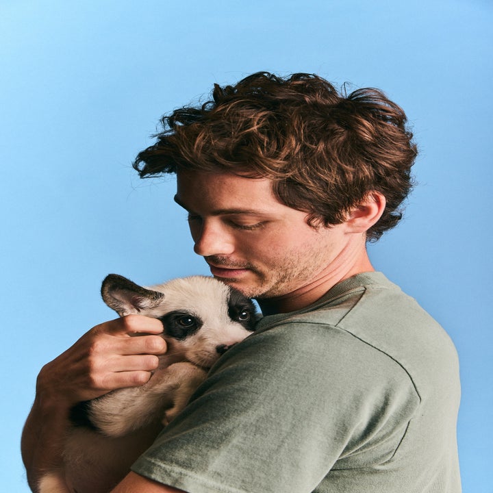 Person gently holding a small dog against their chest, looking down affectionately