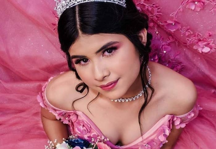 Persona con vestido de gala, corona y ramo de flores, posando