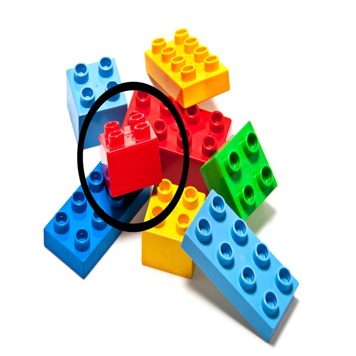 Stack of assorted toy building bricks scattered randomly