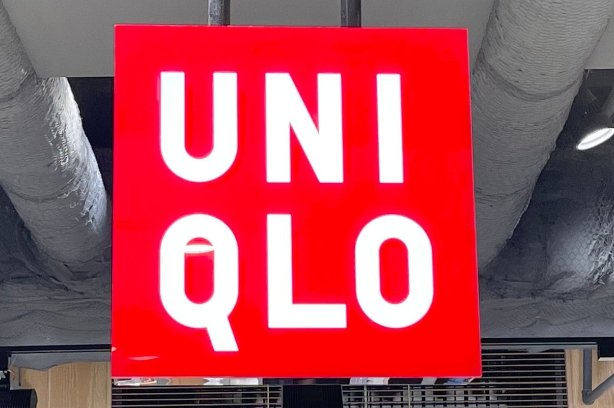 Uniqlo store interior showing a red and white sign and shelves of folded clothing priced at 3,990 yen