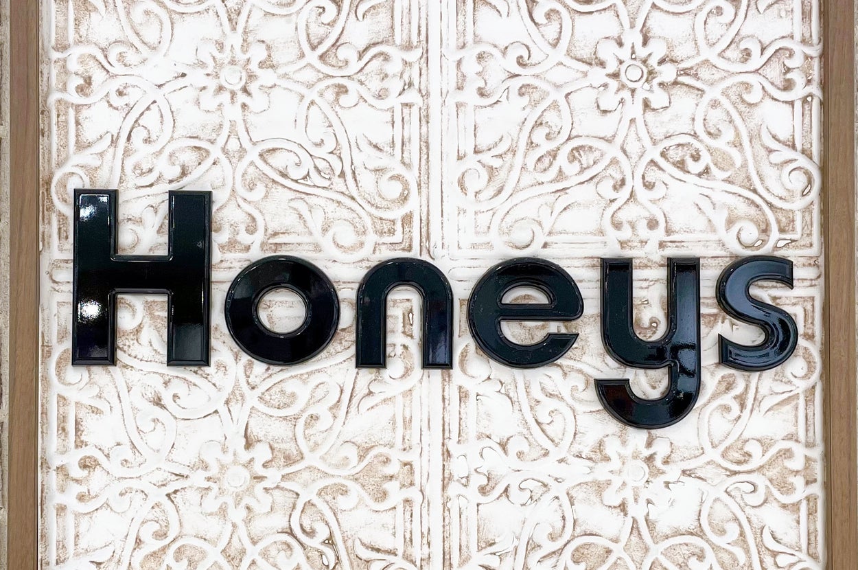 装飾的な背景に「Honeys」と書かれた看板。