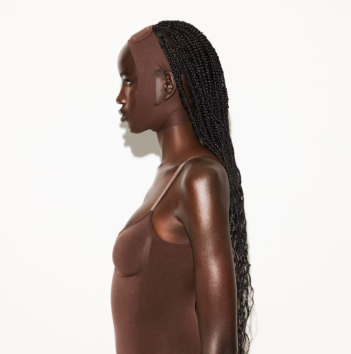 Skims model wearing a fitted face wrap, looking to the side