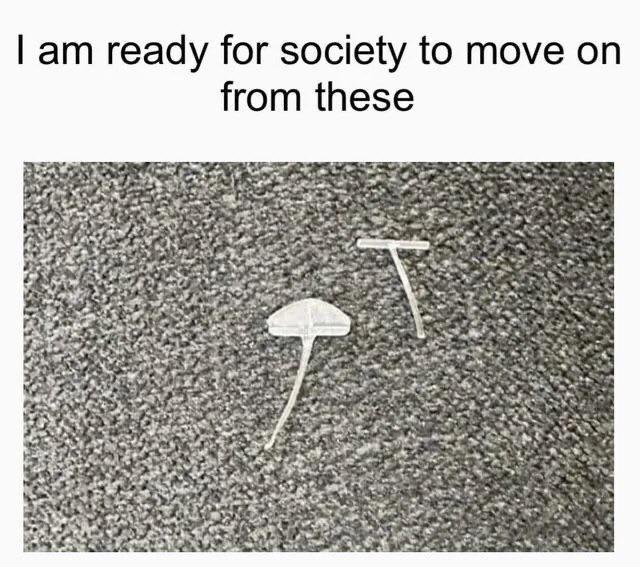 Plastic clothing tag pieces on carpet with text: &quot;I am ready for society to move on from these.&quot;