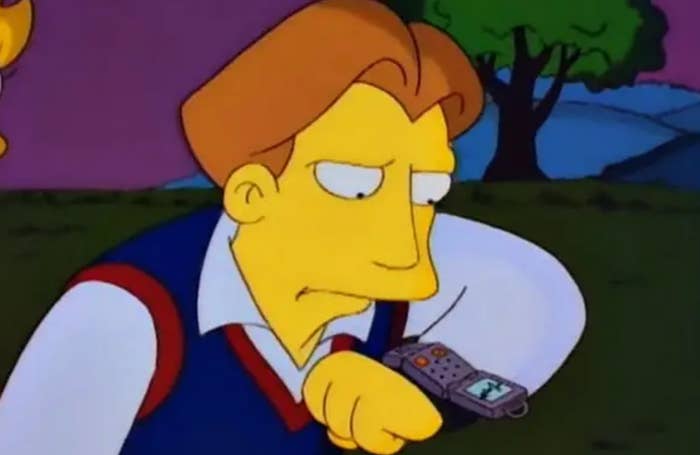 Animated character gazing at a futuristic wrist device with concern. A tree and mountains are in the background