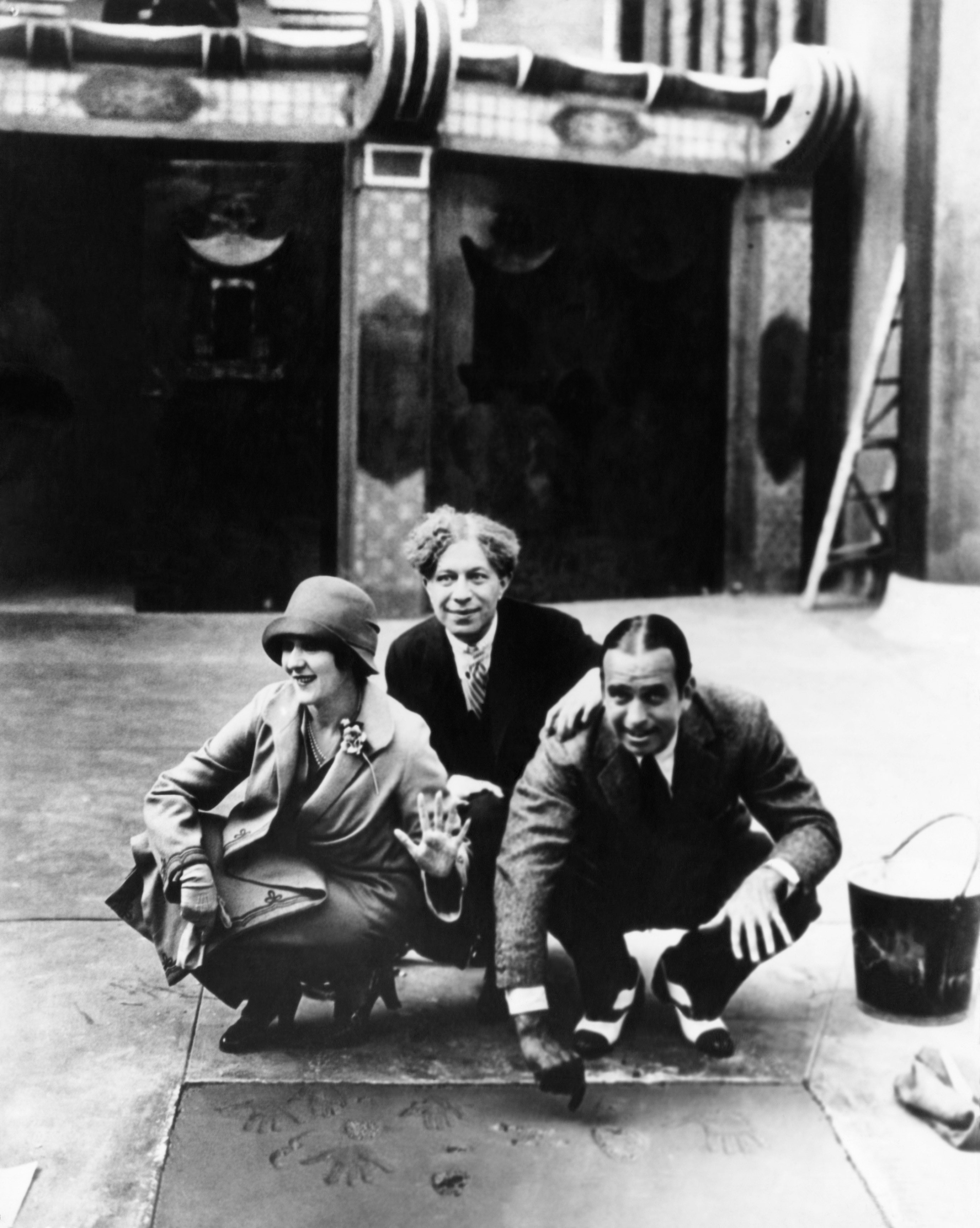 Three radical astatine a handprint ceremonial extracurricular a theater, smiling, with 2 crouching and 1 lasting down them, dated from aboriginal 20th century