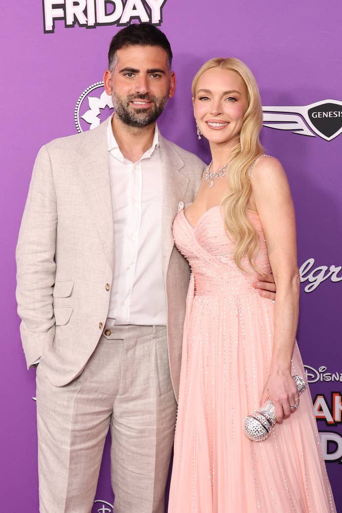 Bader Shammas in a suit and Lindsay Lohan in a strapless dress with a microphone clutch in her hand at the Freakier Friday premiere