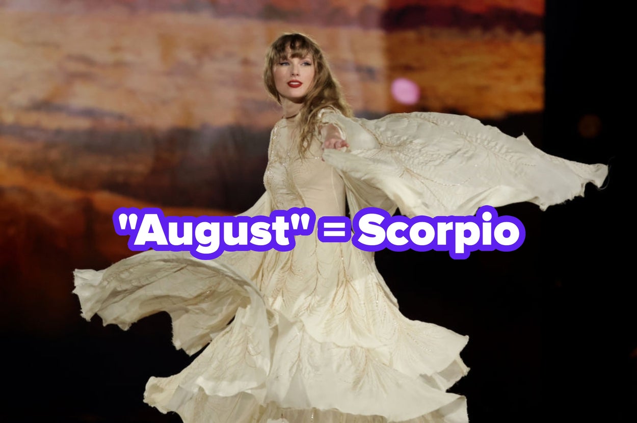 Taylor Swift performs on stage in a flowing, elegant gown with layered details with text "august = scorpio"