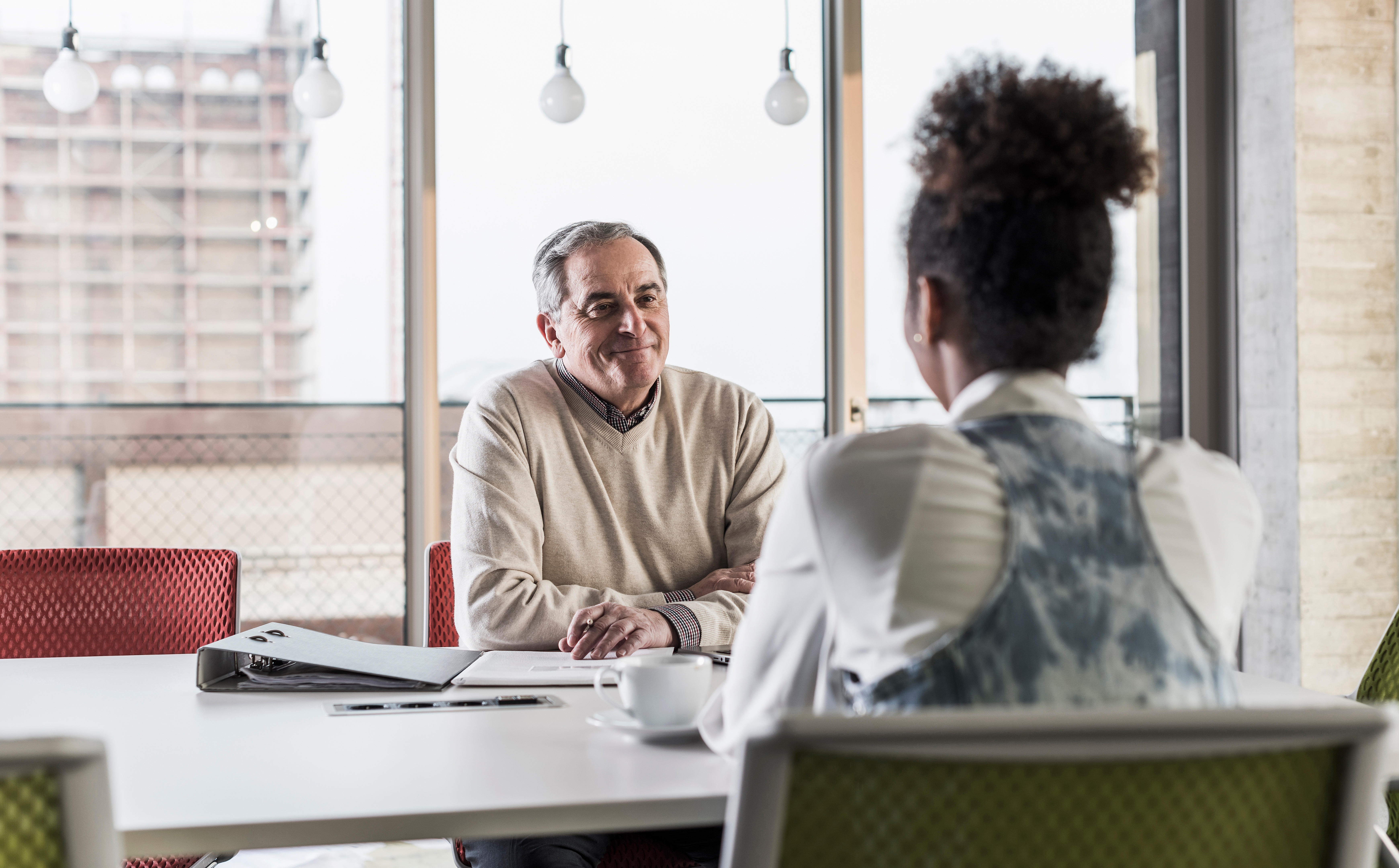 Two people having a professional meeting at a table in a modern office setting