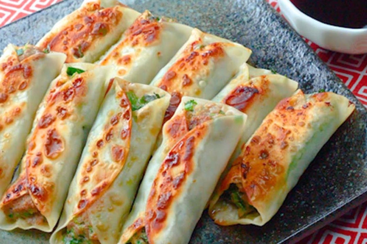 皿に盛られた焼き餃子と小さな醤油の入った容器。食欲をそそるシーン。