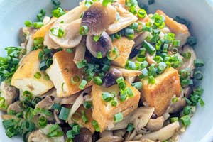 きのこと揚げ出し豆腐が入ったボウルの料理。上に刻んだネギがかかっている。