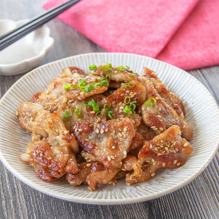 お皿に盛られた豚こま切れ肉のカリカリしょうが焼き。小ネギがトッピングされています。