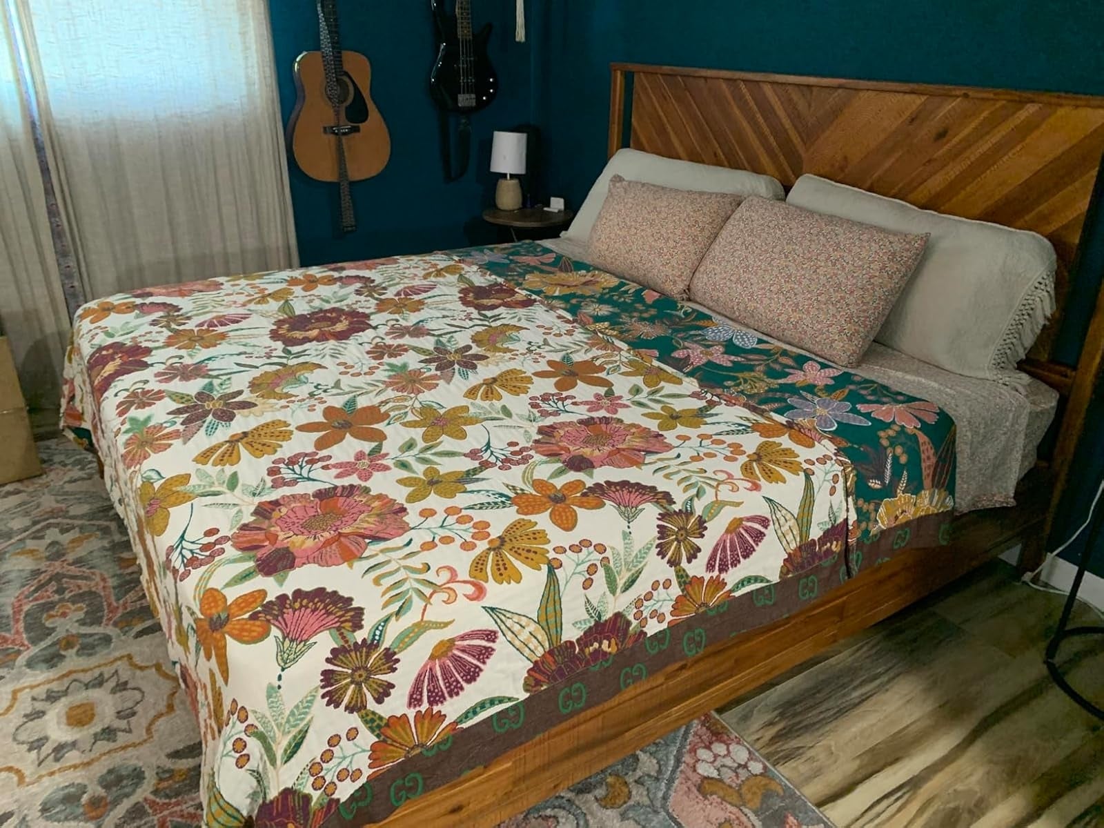 Cozy chamber  with a woody  furniture  featuring a floral quilt, 2  decorative pillows, and guitars hanging connected  the wall